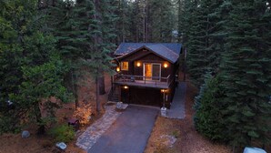A cabin with a deck, surrounded by dense forest. - Cozy Tahoe Retreat w/ Hot Tub, Movie Room & Forest Views 10th ave 2 by Avantstay (Tahoma)