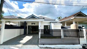 A residential house with a tiled roof, a gated entrance, and a covered porch. - Baiyok Villas Near Kathu Waterfall (Kathu)