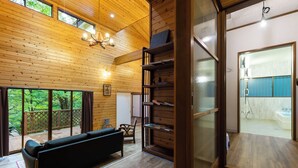 A wooden interior with a sofa, shelves, and a view of a bathroom. - rinne 2nd living Sauna Villa Nasu (Nasu)