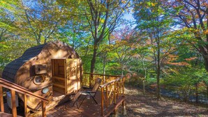A wooden cabin with a deck, surrounded by autumn foliage. - rinne 2nd living Sauna Villa Nasu (Nasu)