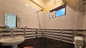 A bathroom with a white sink, a toilet, and a shower area. - Triund View Homestay (Dharamshala)