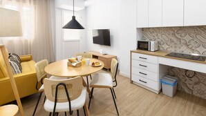 A compact living space with a dining area, kitchenette, and a sofa. - TH Peset Aleixandre 5D (Valencia)