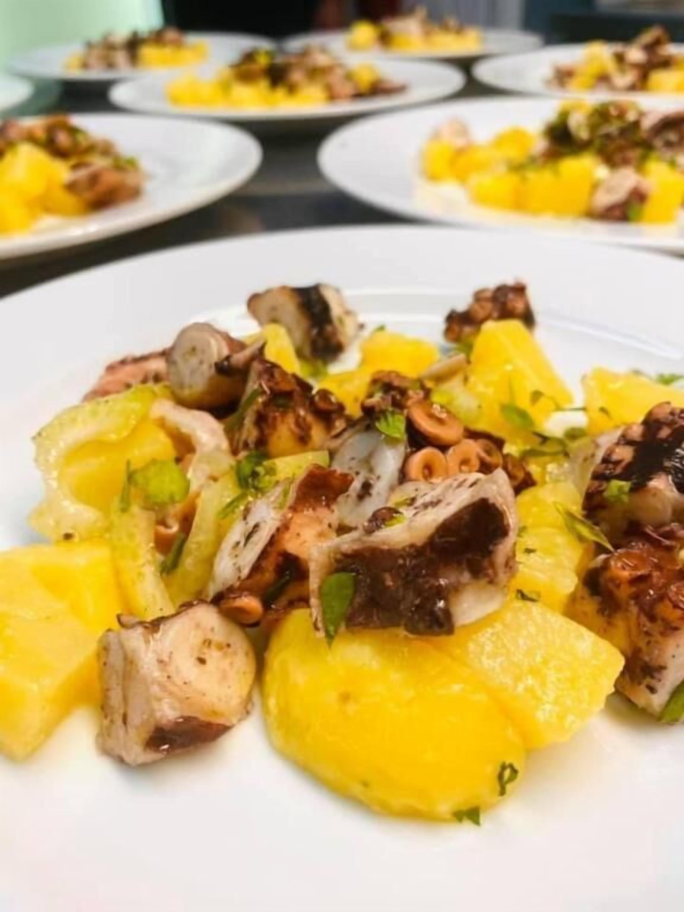 A plate of grilled octopus with lemon and herbs.