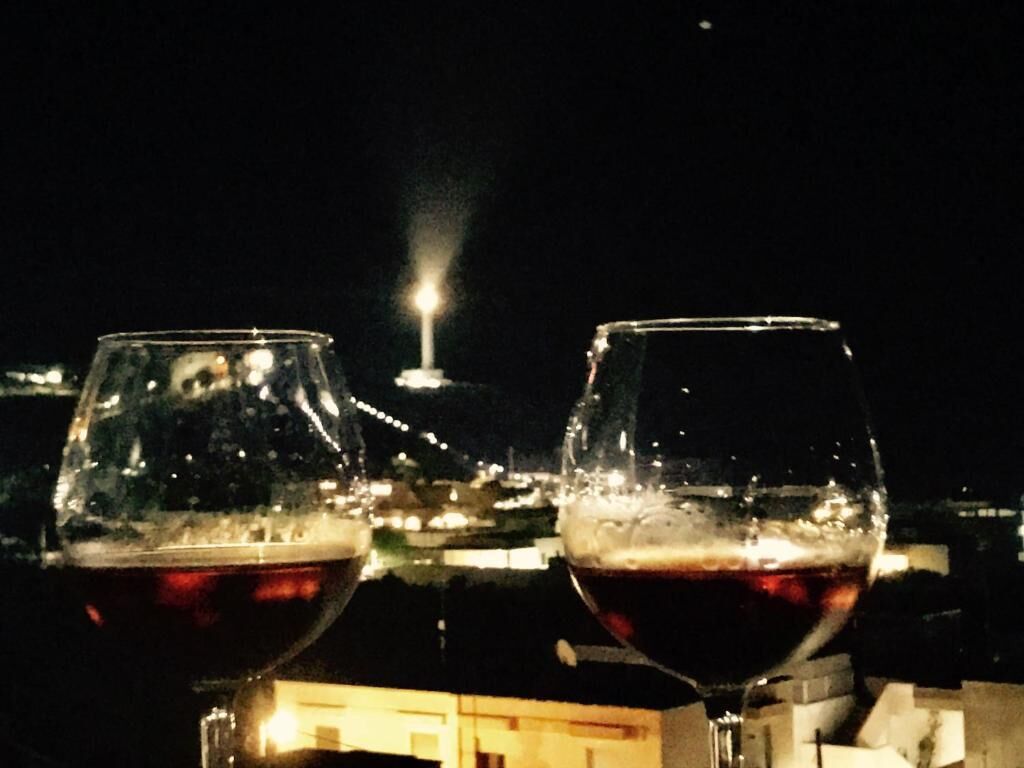 Two wine glasses with a cityscape in the background.