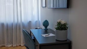 A modern room with a desk, chair, and a potted plant. - Cosy is a very cozy modern facility in soft colors, center of Bari (Bari)
