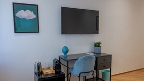 A modern room with a desk, chair, and a flat-screen TV mounted on the wall. - Cosy is a very cozy modern facility in soft colors, center of Bari (Bari)