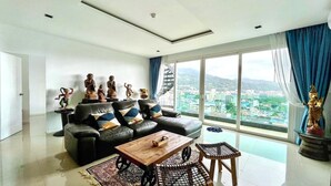A modern living room with a sofa, coffee table, and decorative statues. - Emerald Terrace Patong (Patong)