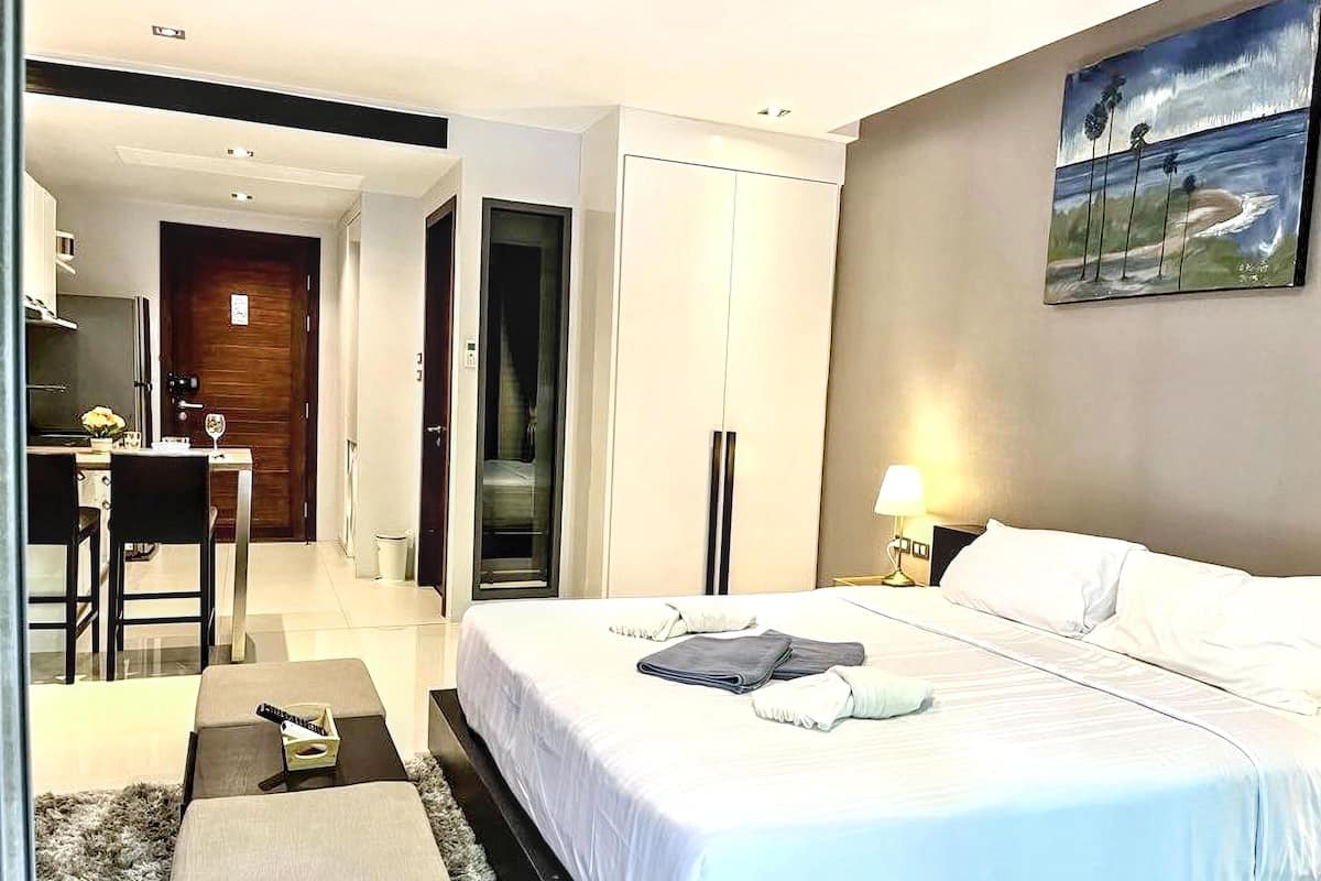 A hotel room with a bed, a desk, and a chair.