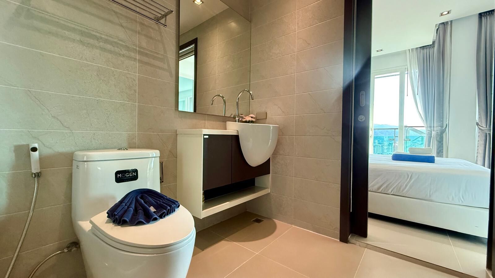 A modern bathroom with a toilet, sink, and shower.