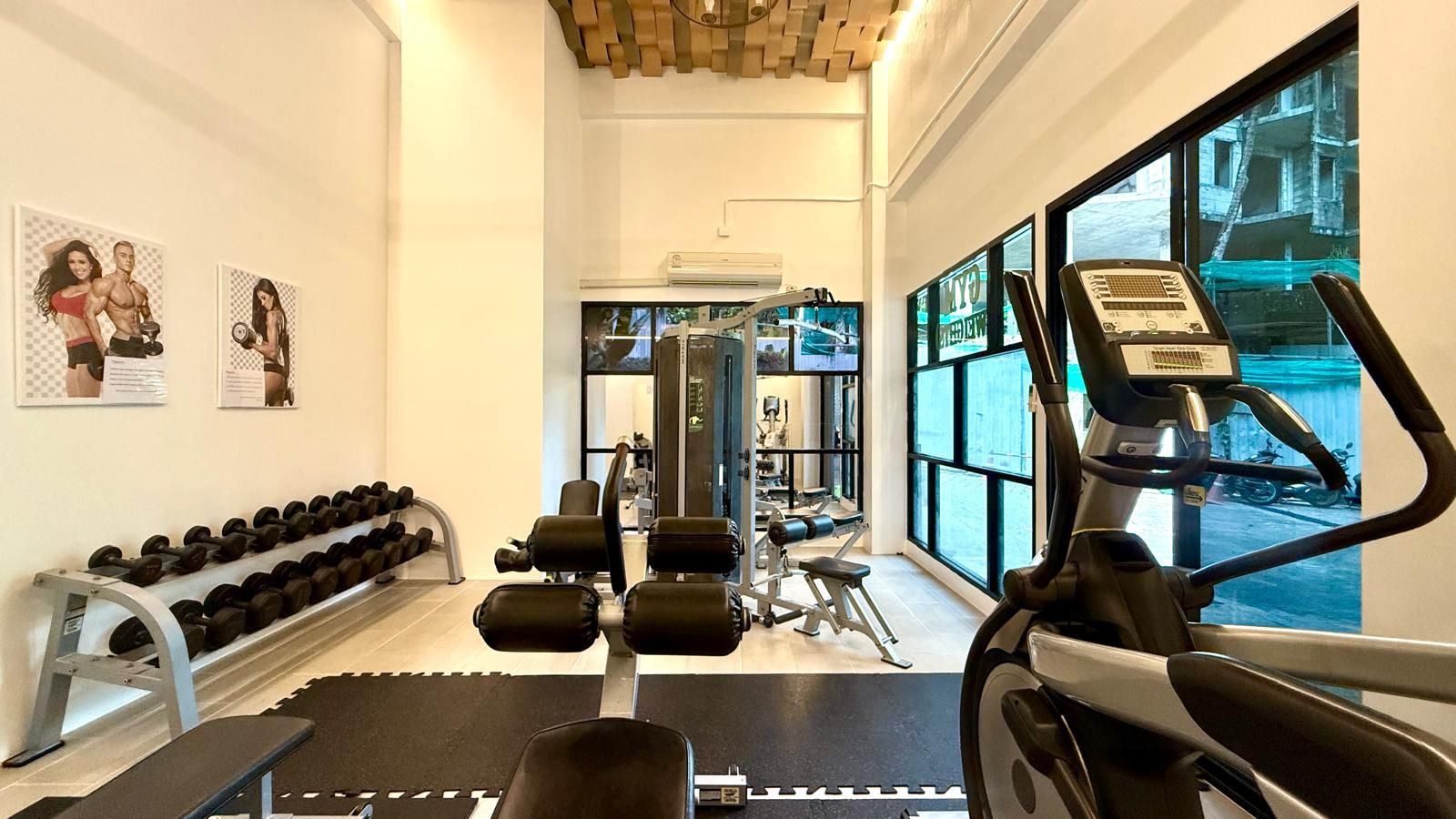Una palestra con attrezzi per esercizi, manubri e tapis roulant.