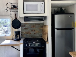 A compact kitchen with a gas stove, a microwave, a refrigerator, and a coffee maker. - Charming California Glamping Retreat near Warner Springs (Warner Springs)