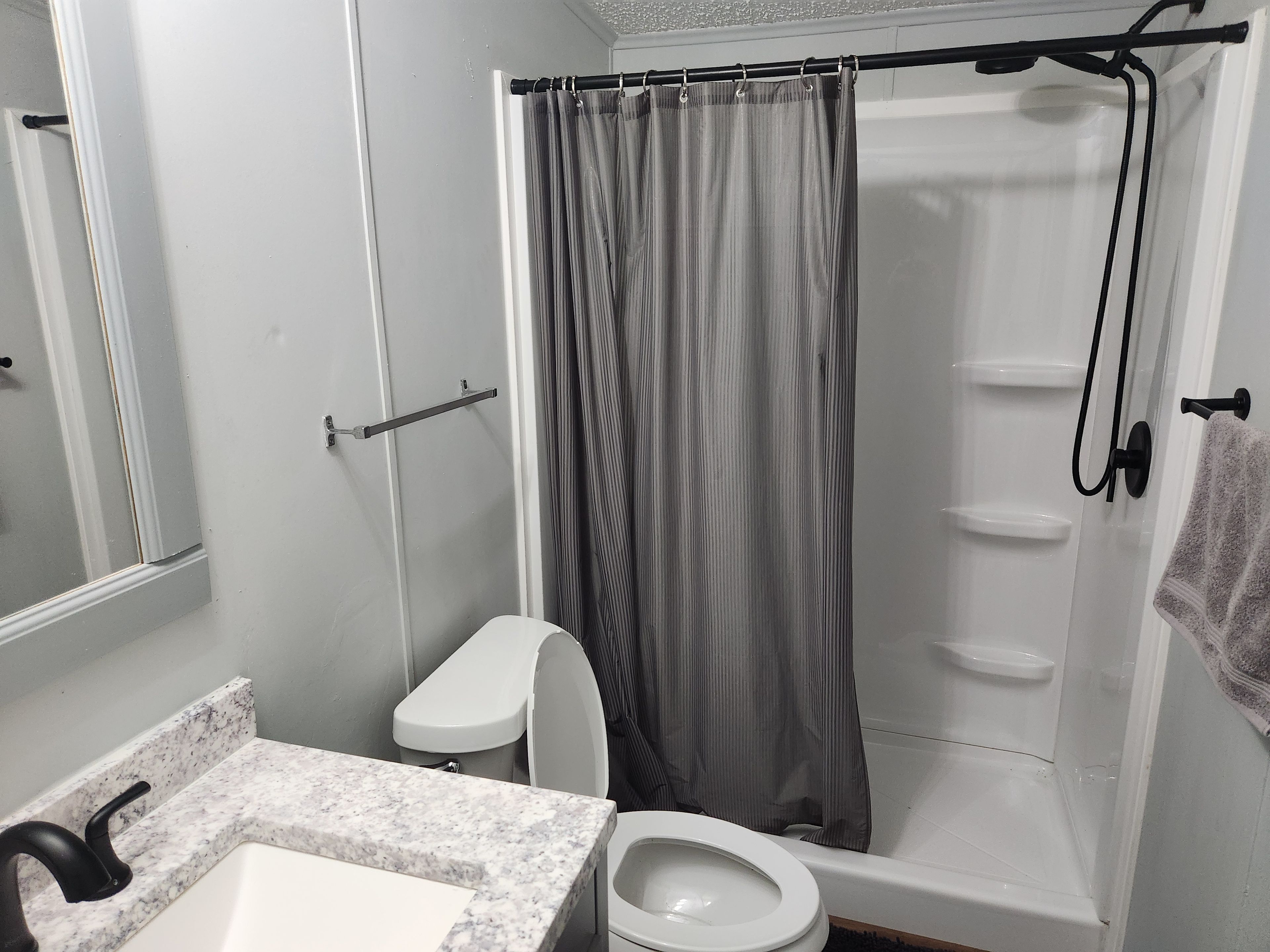 Une salle de bain comprenant des toilettes, un lavabo et un espace douche.