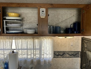 A kitchen with a wooden cabinet, a water heater, and a window with a curtain. - Shabby Chic Warner Springs Rental at a Ranch Ideal for Glamping in California (Warner Springs)
