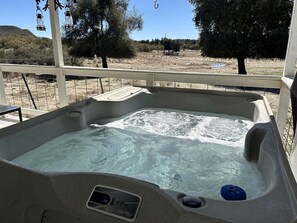 A hot tub with a control panel, surrounded by a white railing, with a view of a dry landscape and trees. - Shabby Chic Warner Springs Rental at a Ranch Ideal for Glamping in California (Warner Springs)