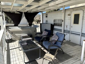 An RV with a covered patio area featuring a grill, outdoor seating, and a water cooler. - Shabby Chic Warner Springs Rental at a Ranch Ideal for Glamping in California (Warner Springs)