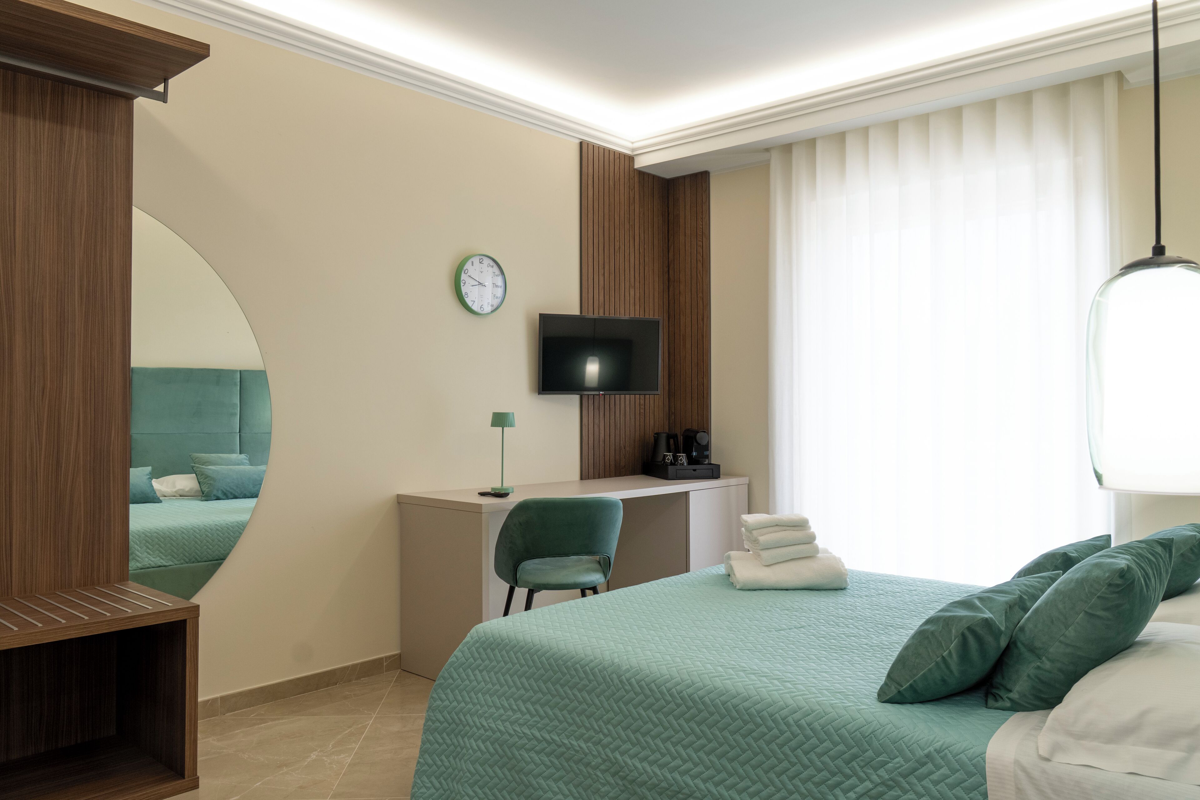 Une chambre d’hôtel équipée d’un lit, d’un bureau, d’une chaise, d’une télévision et d’un miroir.