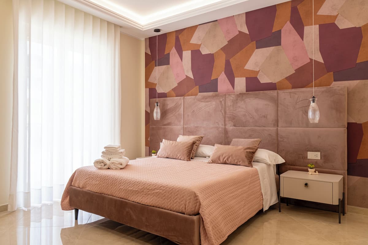 Un dormitorio moderno con una cama grande, una mesita de noche y un adorno en la pared.