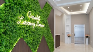 Un hall con una pared verde y un letrero que dice "Amabile Luxury Rooms".