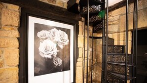 Een zwart-wit foto in een lijst van rozen aan een muur.