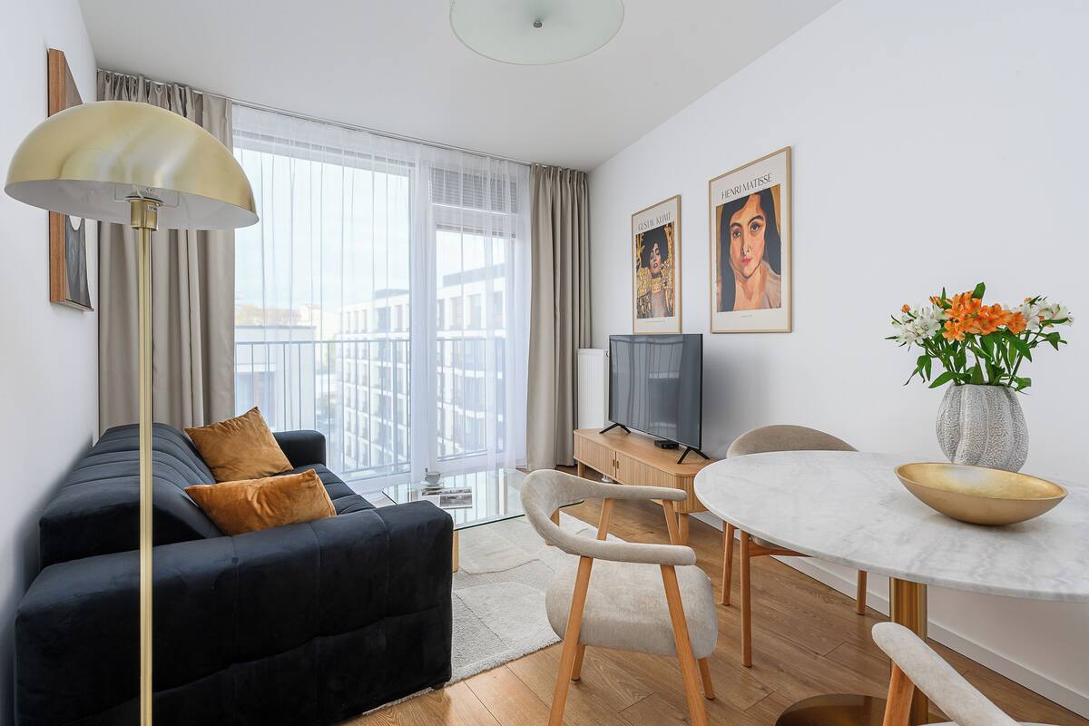 Un salon moderne avec un canapé, une table à manger et un téléviseur.