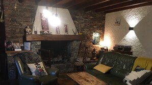 A cozy living room with a stone fireplace, leather furniture, and a wooden coffee table. - Charming Mountain House in the Heart of the Pyrenees (Garin)
