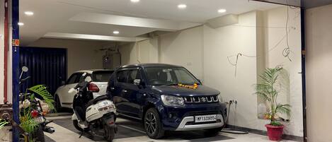 A modern building entrance with a blue car and a scooter parked inside.