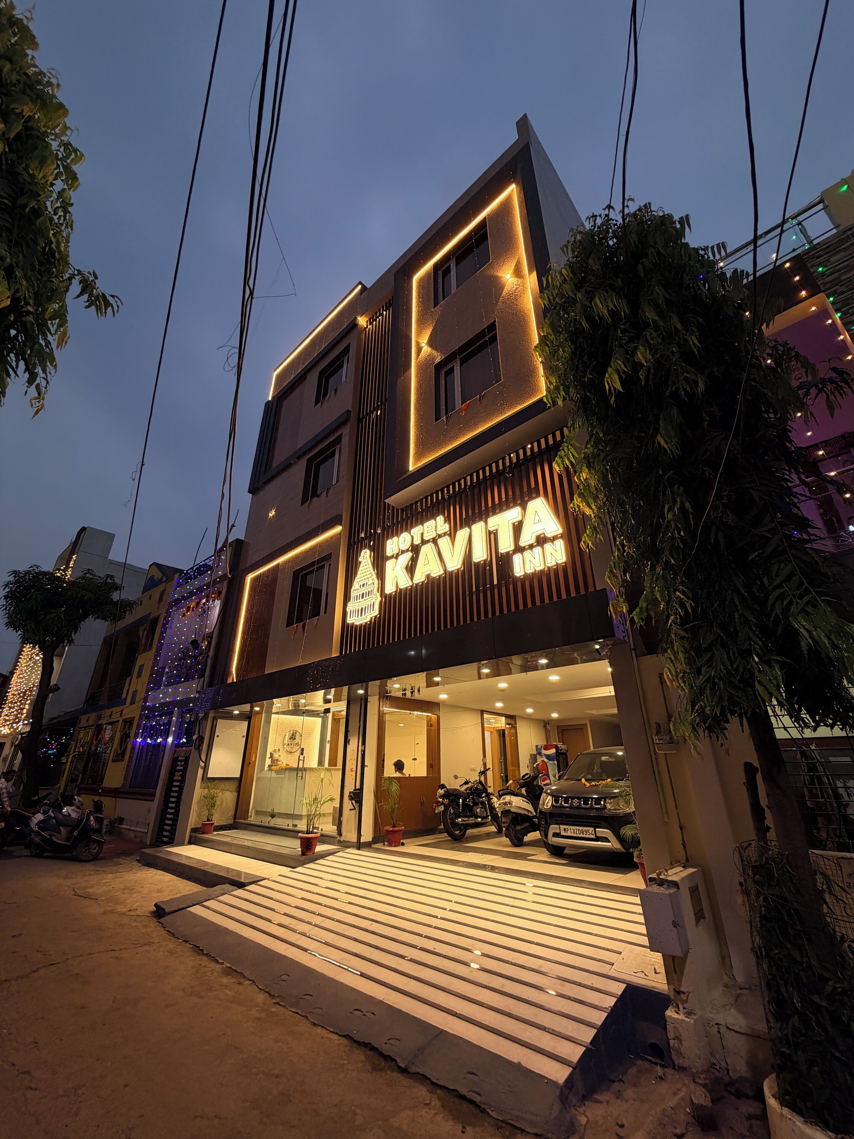 Un hotel moderno con un cartel llamativo que dice "Hotel Kavita Inn".
