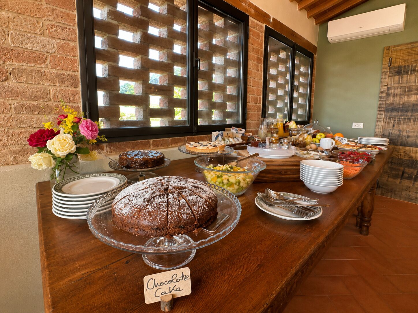 Un buffet proposant une variété de plats, notamment un gâteau au chocolat, des fruits et des boissons.