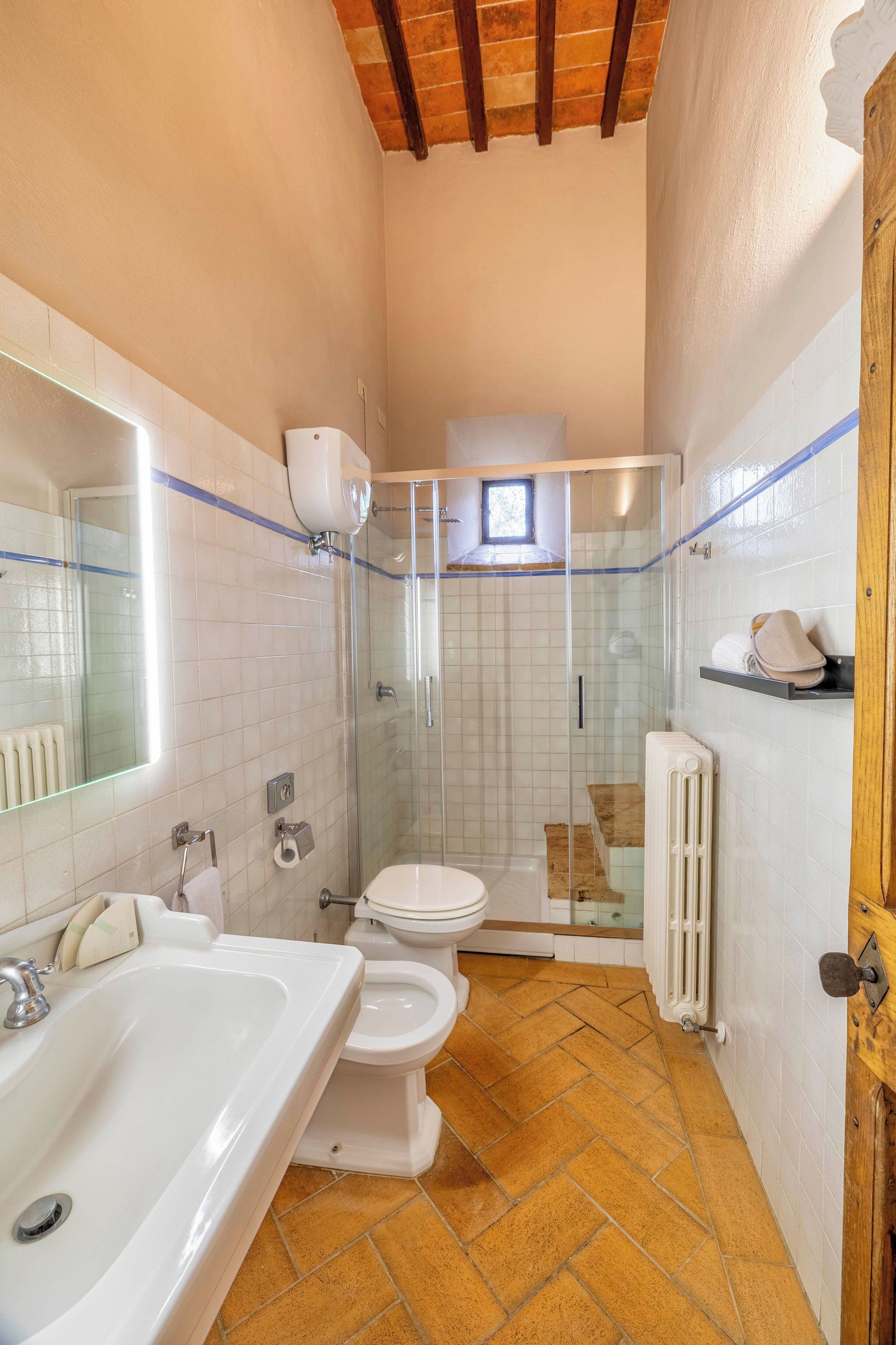 A bathroom with a white sink, toilet, and shower.