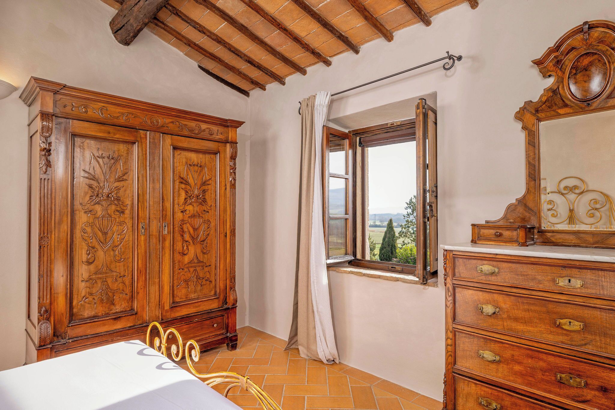 Ein Schlafzimmer mit großem Kleiderschrank, einem Fenster mit Ausblick und einem Spiegel.