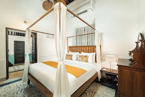 A four-poster bed with a canopy, a bedside table with a lamp, and a wooden nightstand. - Saligao - Casa De Mello C 1863 (Saligao)