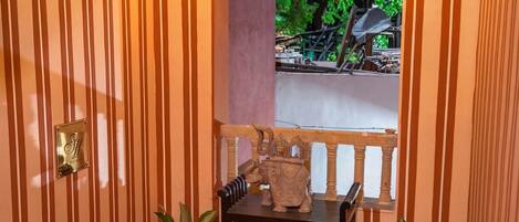 A staircase with striped walls, a wooden railing, and two potted plants.