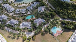 An aerial view of a resort with multiple buildings, a large pool, and a beach area. - Spacious ocean view king bed villa 2 minutes from the restaurant pool and beach (FreeTownst)