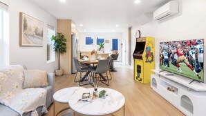 Een moderne woonkamer met een bank, een eettafel en een televisie.
