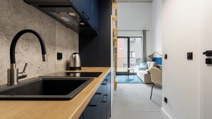 Een moderne keuken met een dubbele spoelbak, een roestvrijstalen kraan en een waterkoker.