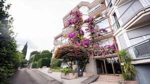 En flervåningsbostadsbyggnad med balkonger som är prydda med blommande växter.