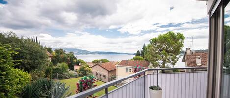 A balcony with a view of a residential area and the sea.