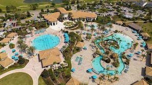 A resort with multiple swimming pools, sun loungers, and palm trees.