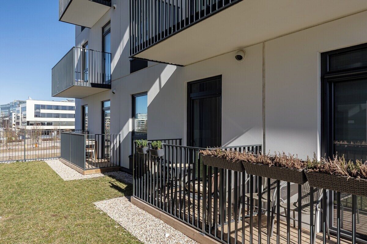 Un bâtiment moderne doté d’un balcon, d’un espace extérieur aménagé et offrant une vue sur la ville.