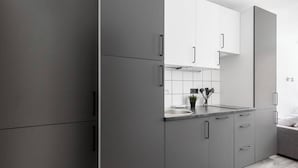 Une cuisine moderne avec des meubles gris, un plan de travail blanc et un évier.