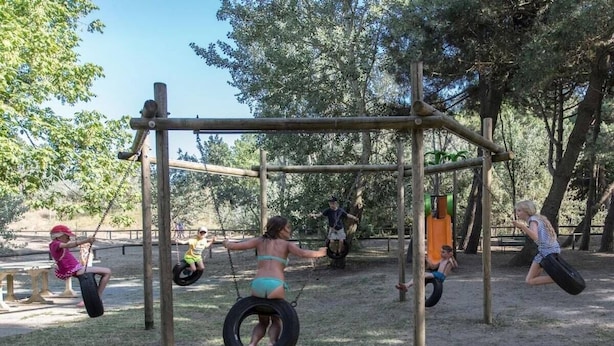 Children playing on a playground with swings and tire swings. - Cozy 2 Bedroom Cabin Sleeps 5 in Lido di Spina, Italy - Perfect Family Retreat (Comacchio)