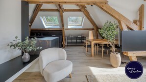 Ein modernes Loft mit freiliegenden Holzbalken, einer Küche, einem Essbereich und einem großen Fenster.