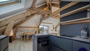 Eine moderne Küche mit Holzbalken, einem Essbereich und Bergblick.