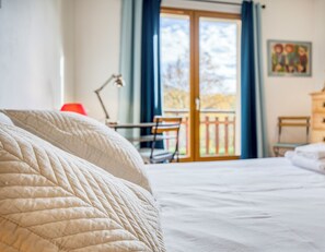 Ein Schlafzimmer mit Bett, Kommode, Schreibtisch und Stuhl.