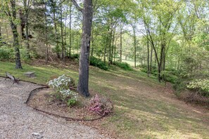Un terrain de camping avec un sentier de gravier, des tables de pique-nique et une zone boisée.