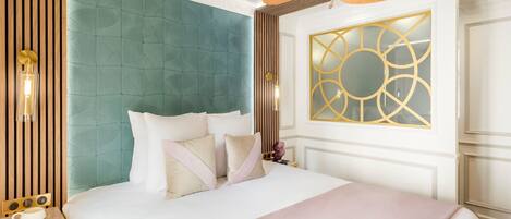 A hotel room with a large bed, a ceiling fan, a decorative wall panel, and a nightstand with a lamp.