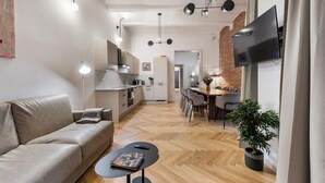 A modern living space with a sofa, dining table, and kitchen area. - easy-flat Votiv - 153sqm Apartment with Terrace (Vienna)