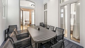 A modern dining area with a round table and black chairs, large windows, and a skylight. - easy-flat Votiv - 153sqm Apartment with Terrace (Vienna)