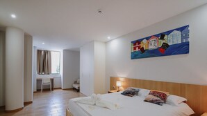 Une chambre d’hôtel avec un lit, un bureau et une chaise.