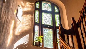 Un escalier doté d’une rampe en bois et d’un luminaire décoratif au plafond.